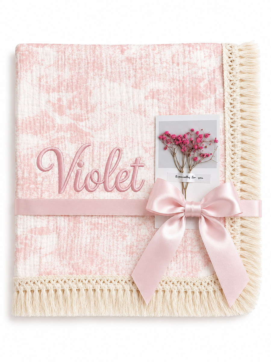 Blush Naturel pink patterned muslin blanket with Violet embroidered in pink, cream fringed edging and pale pink ribbon.