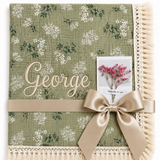 Botanica green floral muslin baby blanket with George embroidered in cream, fringed edging and champagne ribbon.