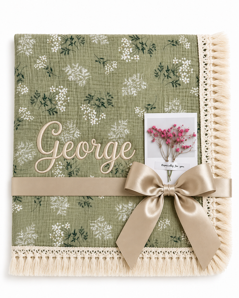 Botanica green floral muslin baby blanket with George embroidered in cream, fringed edging and champagne ribbon.