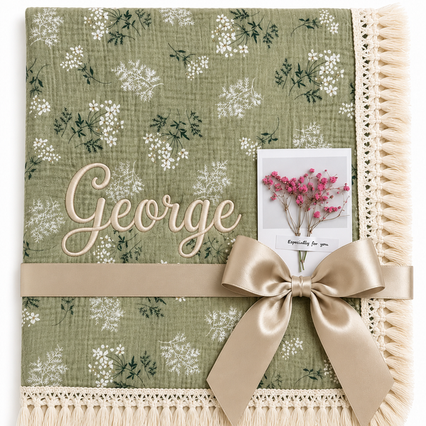 Botanica green floral muslin baby blanket with George embroidered in cream, fringed edging and champagne ribbon.
