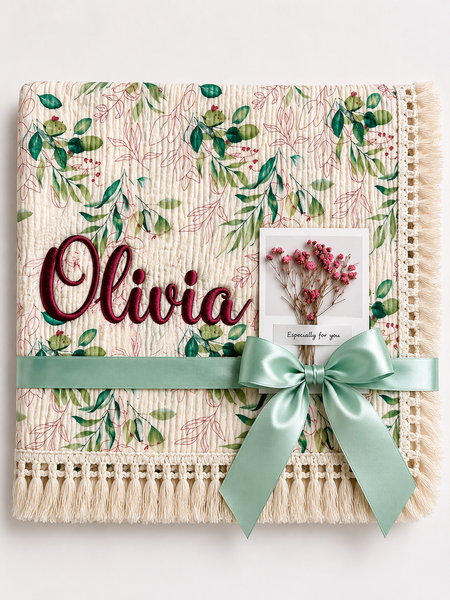 Olives patterned muslin baby blanket with Olivia embroidered in burgundy, cream fringe and mint ribbon.