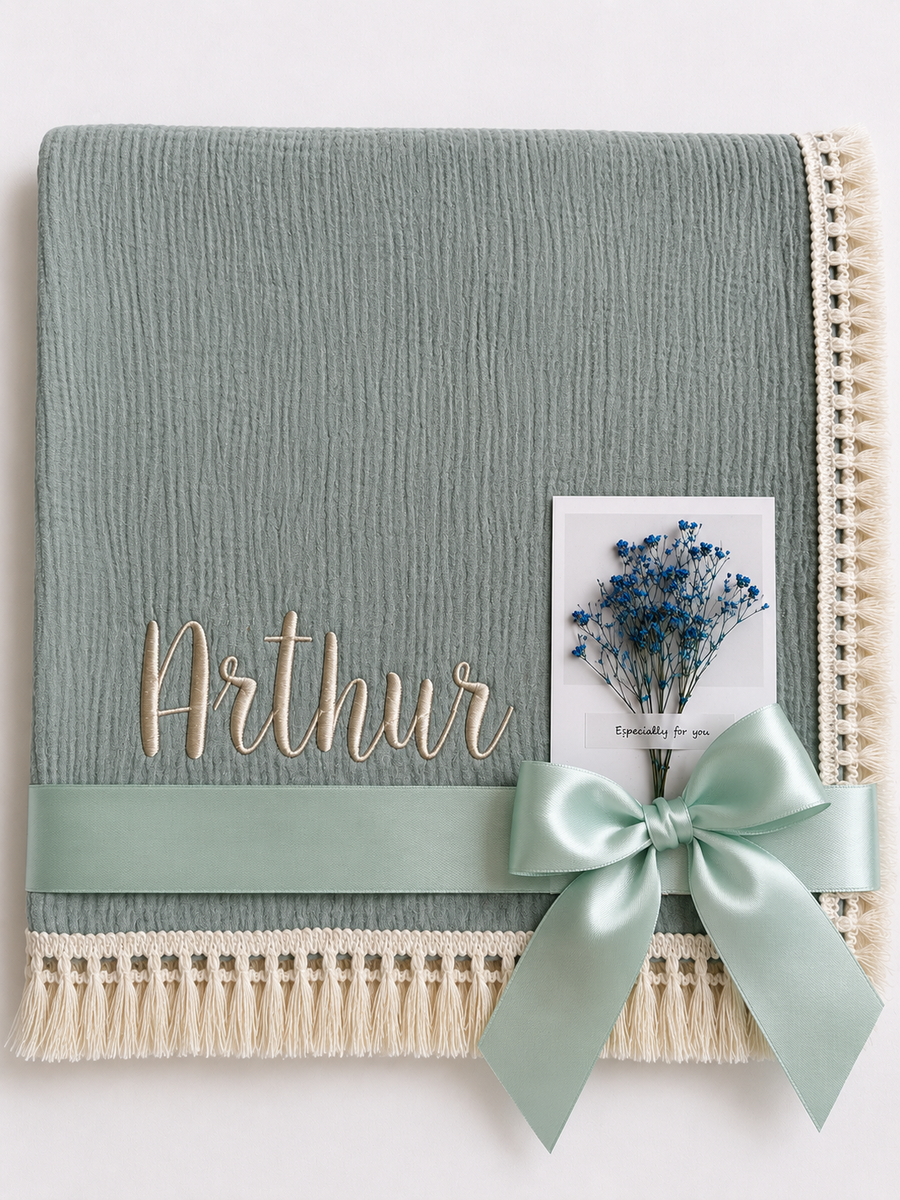 Thyme green muslin baby blanket embroidered with Arthur, with cream fringe and a mint ribbon.